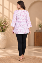 White floral printed short kurti with pink accents, flared sleeves and gathered hem
